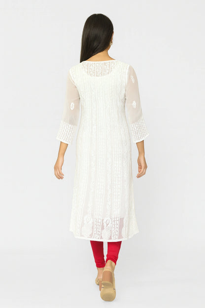 Woman wearing a white embroidered kurta with red leggings on a white background