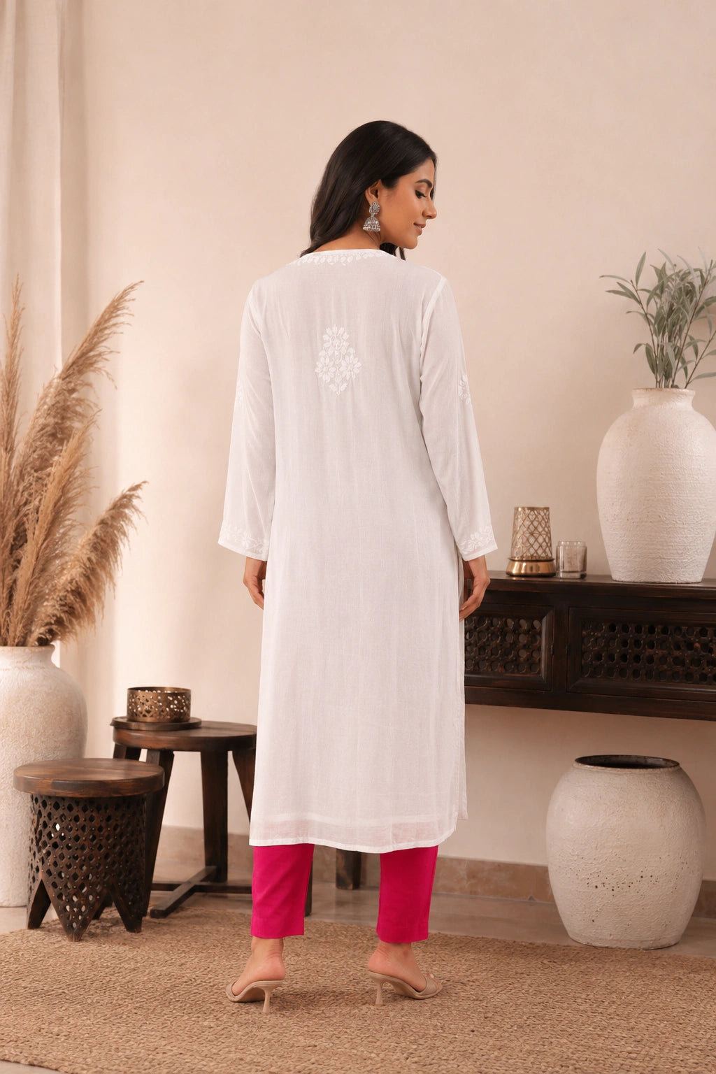 lucknowi chikankari Woman wearing a white kurta with pink pants in a home setting