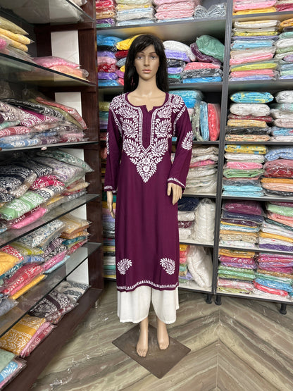 Mannequin wearing a purple embroidered dress in a fabric store.