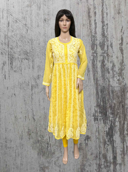 Yellow embroidered dress on a mannequin against a textured gray background