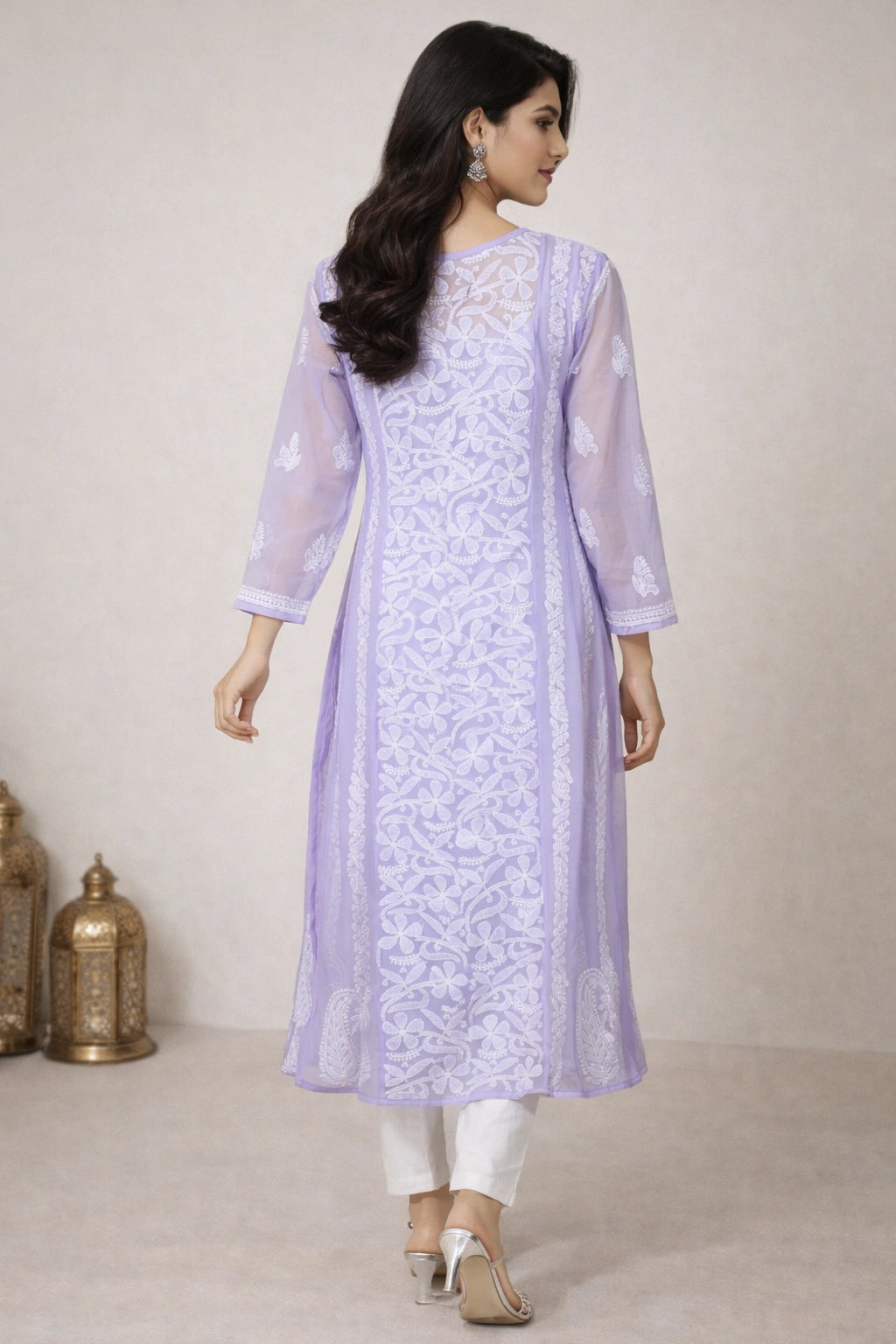 Woman wearing a light purple embroidered kurta with white pants against a neutral background
