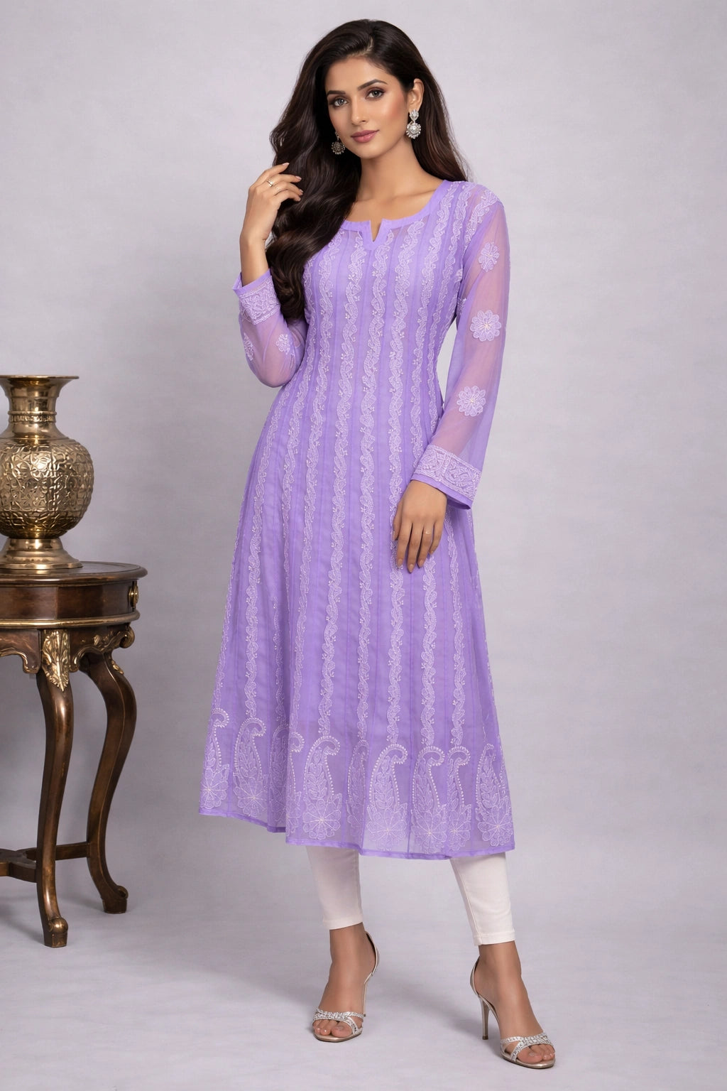 Woman wearing a light purple kurta with white pants against a gray background