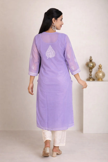A woman wearing a lavender purple kurta with white embroidery on the back and white pants, shown from the back in a studio setting.
