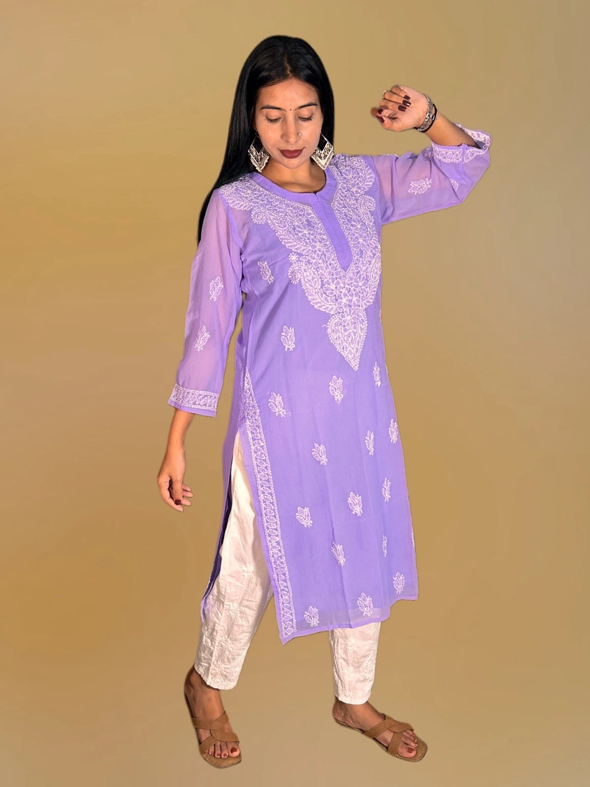 A woman modeling a lavender purple kurta with white embroidery, paired with off-white pants, against a solid beige background.