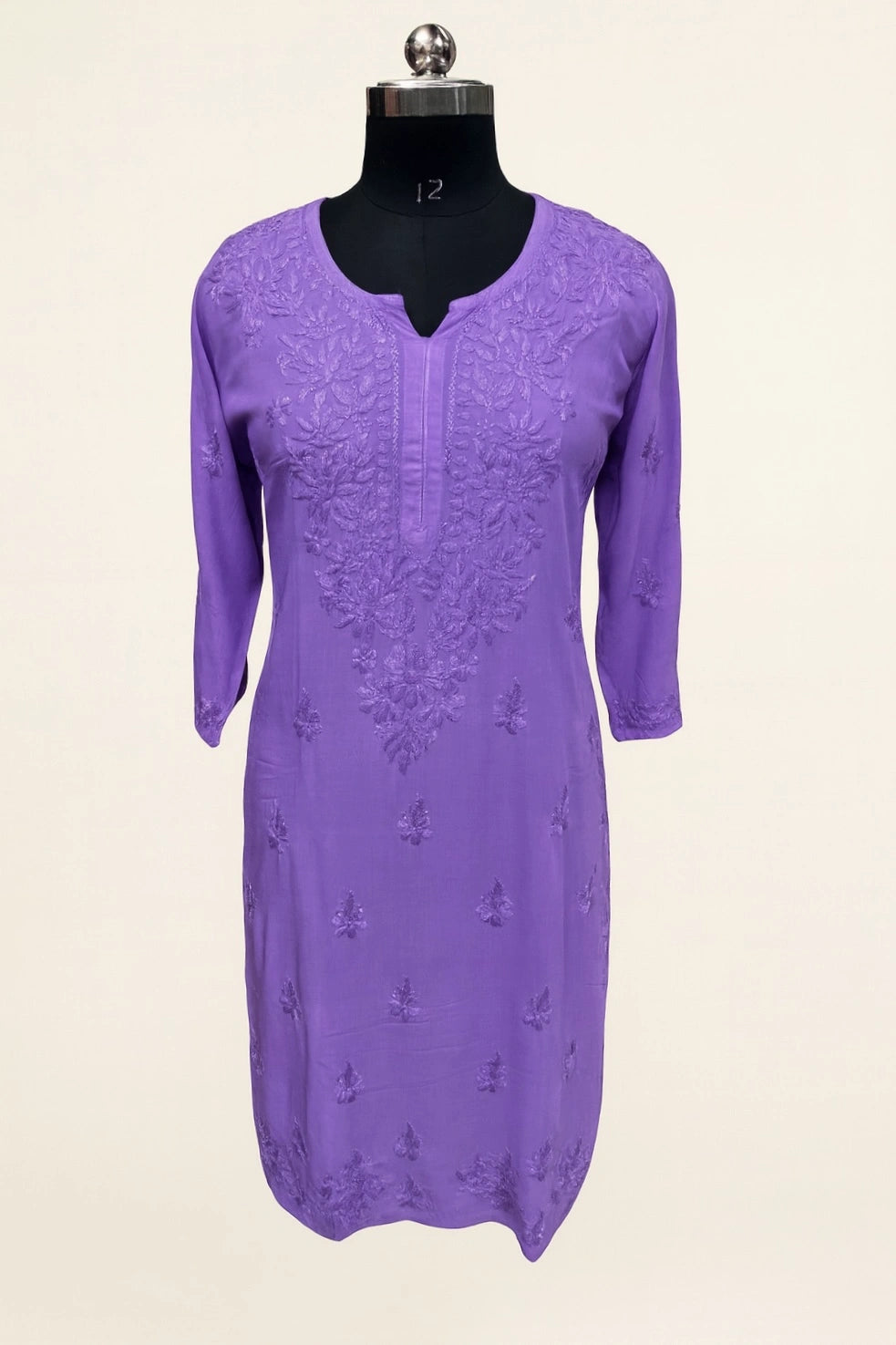 Purple dress with floral embroidery on a mannequin against a white background