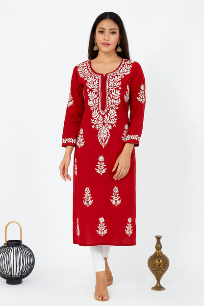 Woman wearing a red embroidered kurta with white pants against a white background