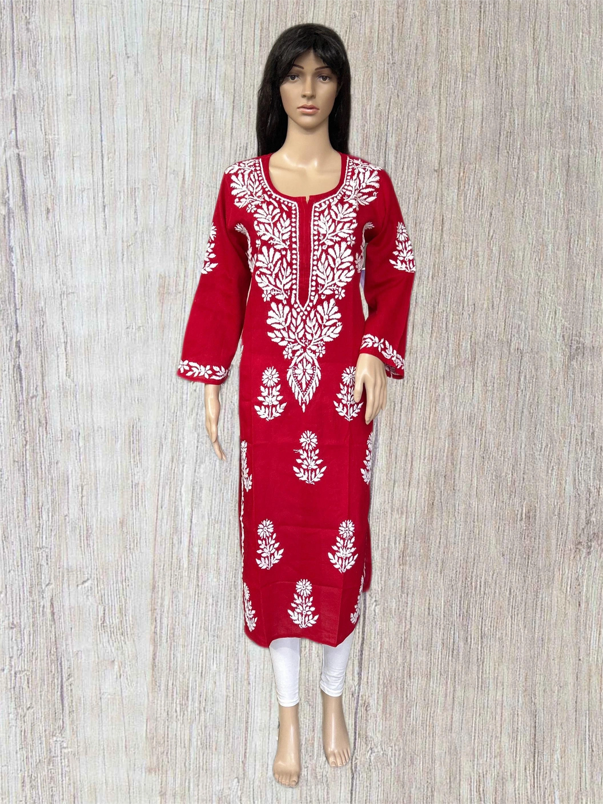Red embroidered dress on a mannequin against a gray background