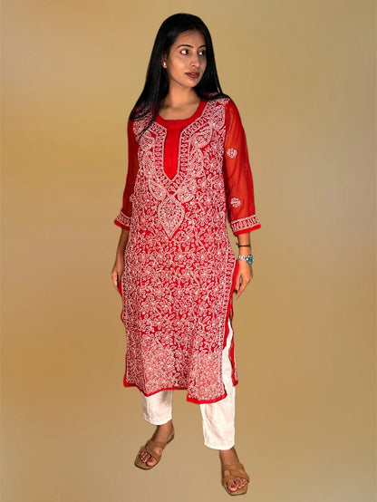 lucknowi chikankari A woman modeling a red and white printed kurta with white pants against a solid beige background.