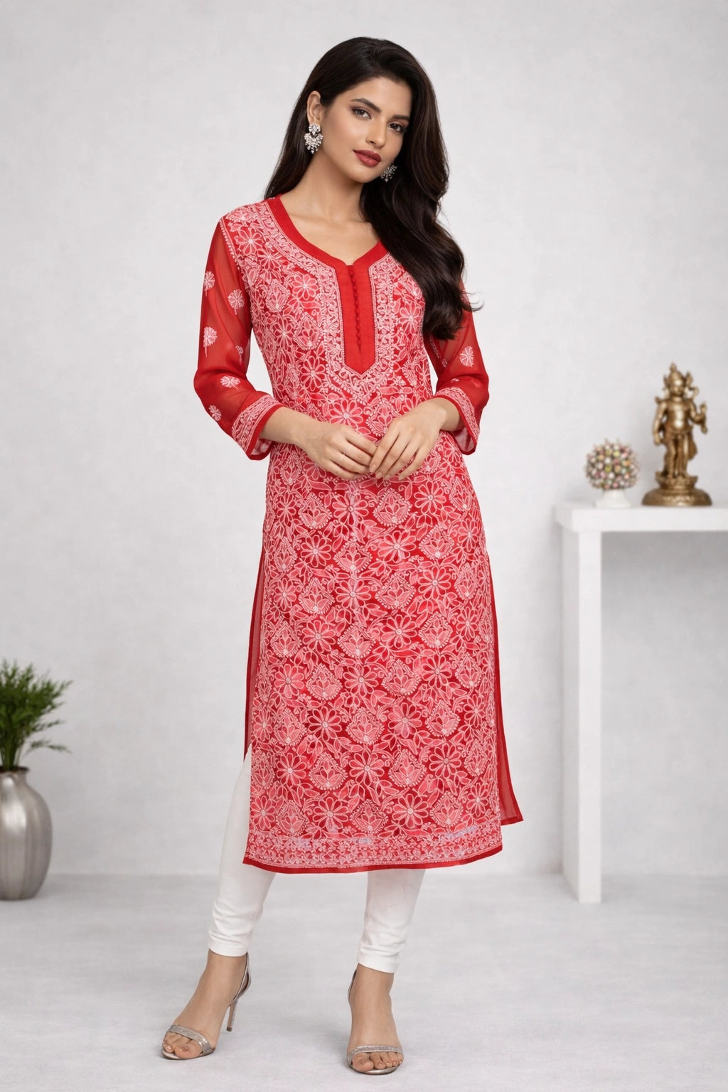 Woman wearing a red and white patterned kurta with white pants on a plain background