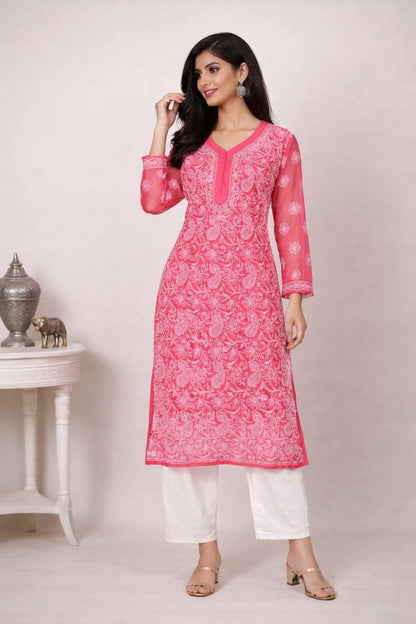 Woman wearing a pink kurta with white pants against a plain background