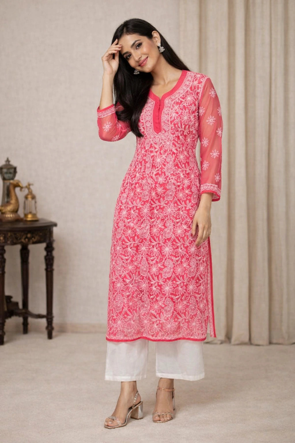 Woman wearing a pink and white lucknowi chikankari traditional outfit with a neutral background