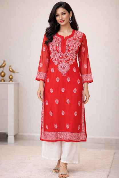 Woman wearing a red embroidered kurta with white pants in a minimalistic setting.