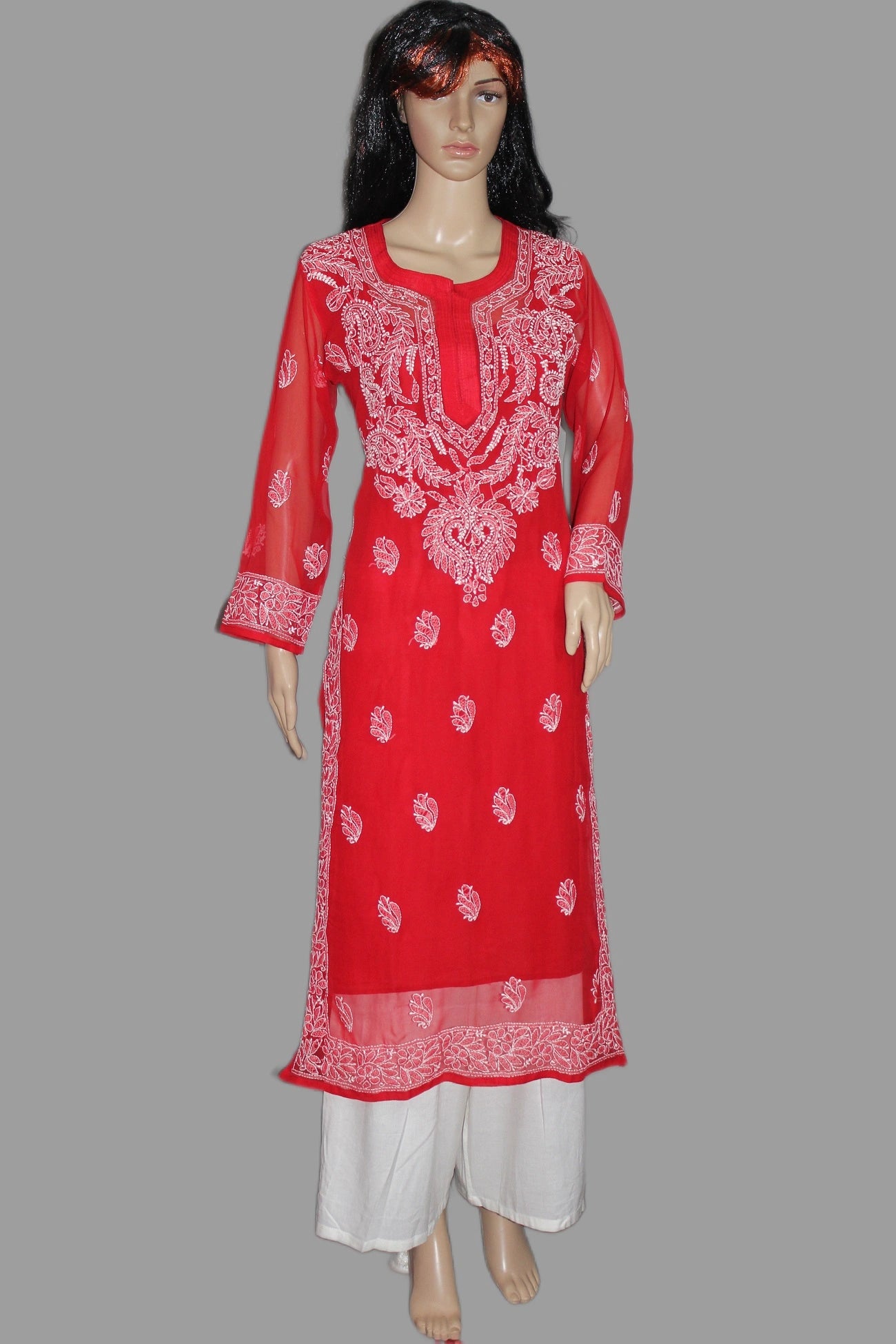 Red embroidered kurta with white pants on a gray background