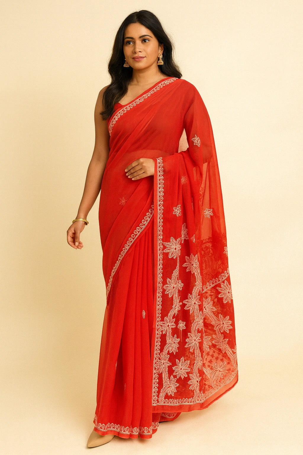 Woman wearing a red saree with white embroidery on a beige background