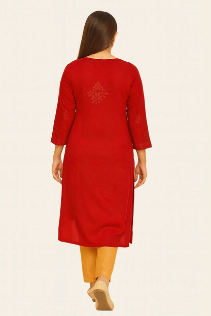 Woman wearing a lucknowi chikankari red kurta with yellow pants on a white background