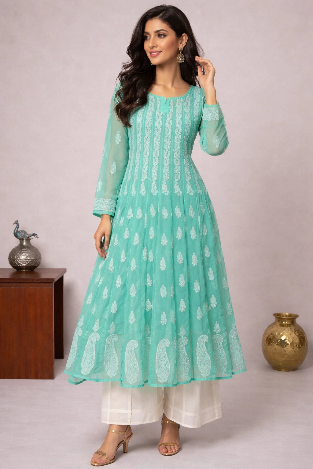 Woman wearing a light blue traditional outfit with white patterns on a plain background