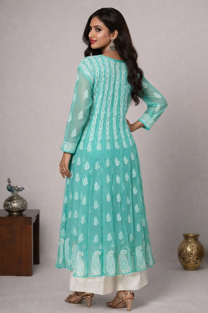 Woman wearing a light blue traditional outfit with white patterns against a neutral background