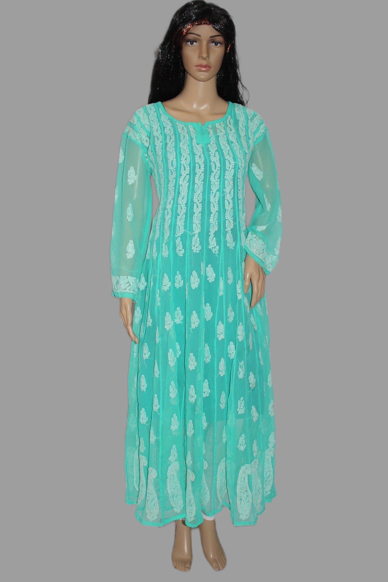 Mannequin wearing a turquoise dress with white patterns on a gray background