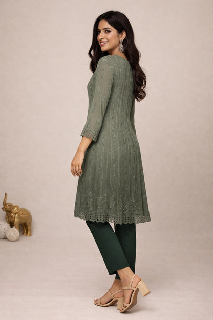 Woman wearing a green kurta with matching pants on a beige background