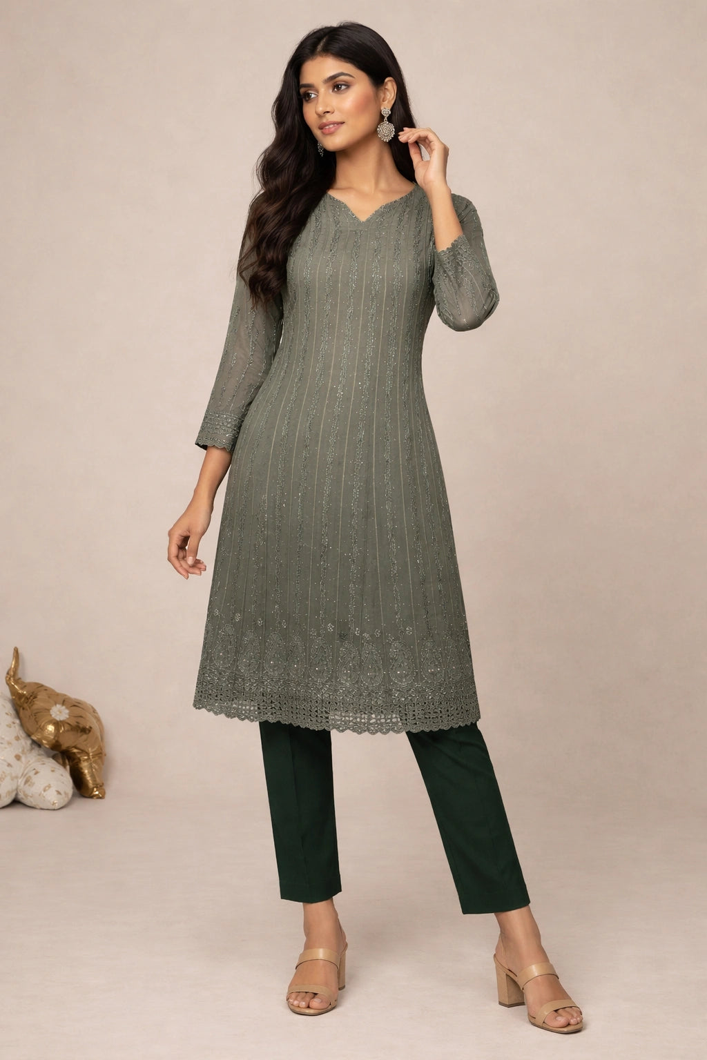Woman wearing a green kurta with black pants against a beige background