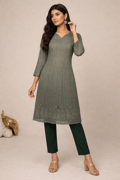 Woman wearing a green kurta with black pants against a beige background