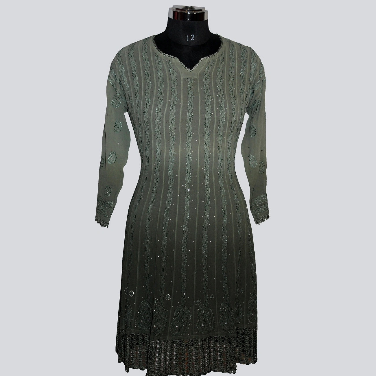 Green dress on a mannequin against a gray background