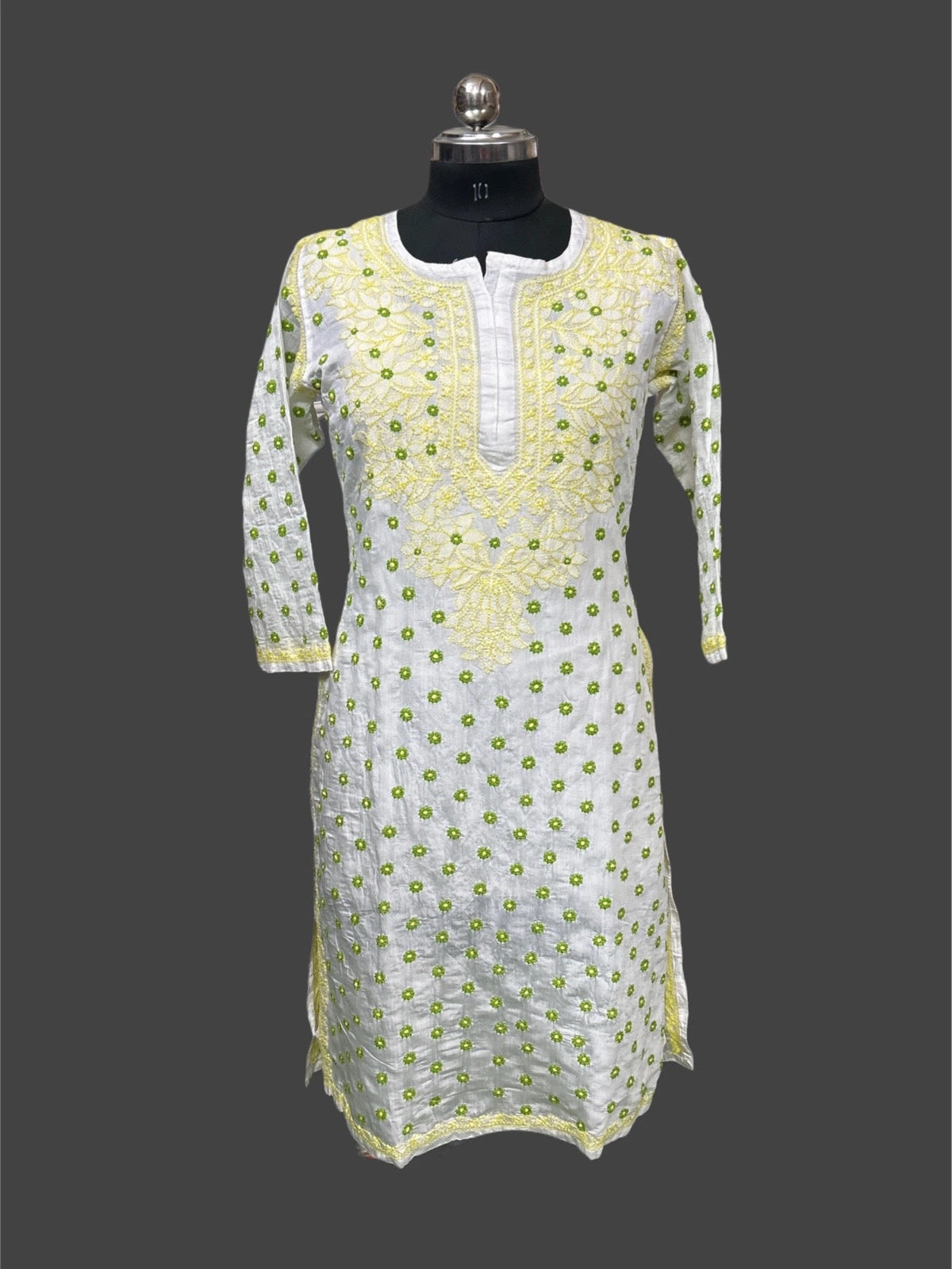 White kurta with green floral embroidery on a mannequin against a gray background