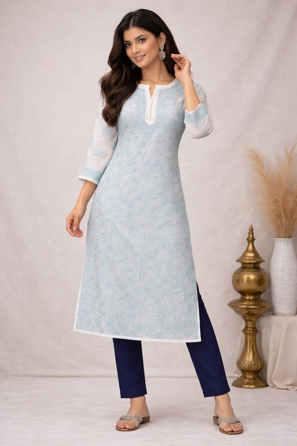 Woman wearing a light blue kurta with white collar and navy pants against a neutral background.