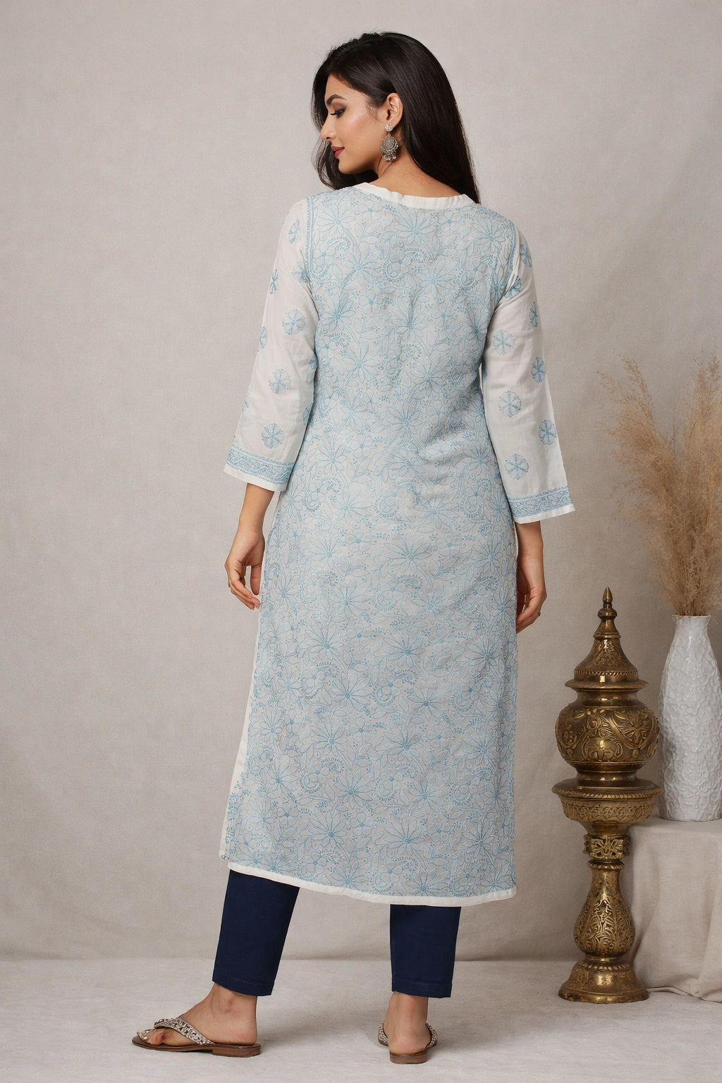 Woman wearing a light blue kurta with white patterns, standing against a neutral background.