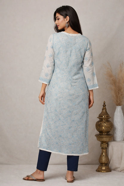 Woman wearing a light blue kurta with white patterns, standing against a neutral background.
