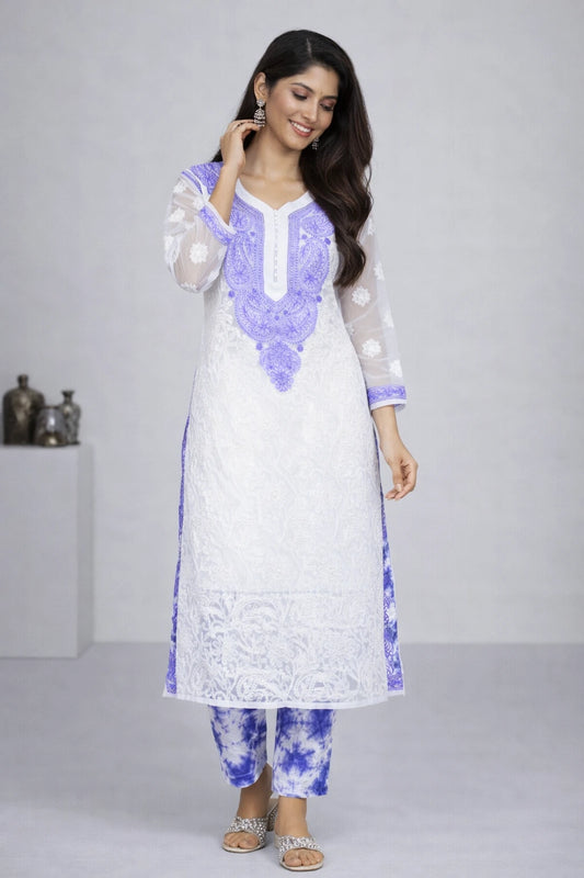 Woman wearing a white and blue embroidered kurta with matching pants on a gray background