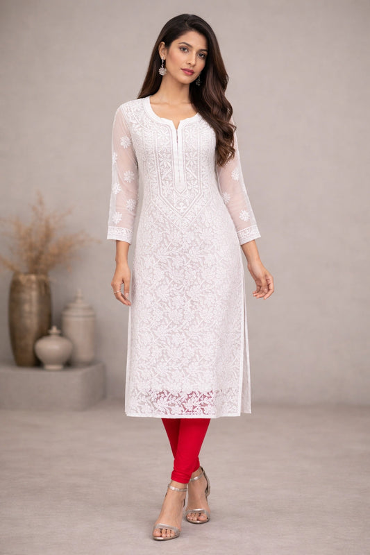 Woman wearing a white embroidered kurta with red pants against a neutral background