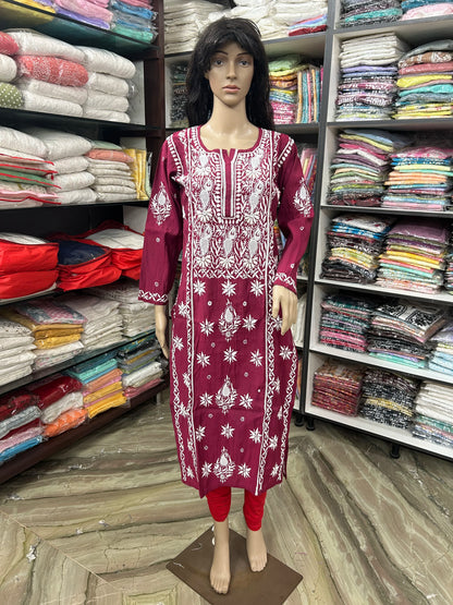 An wine long kurta with white floral embroidery displayed on a mannequin in a clothing store. The kurta features a round neckline, three-quarter sleeves, and white embroidered patterns on the front and cuffs.