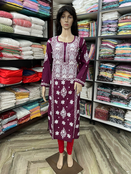 An wine long kurta with white floral embroidery displayed on a mannequin in a clothing store. The kurta features a round neckline, three-quarter sleeves, and white embroidered patterns on the front and cuffs.