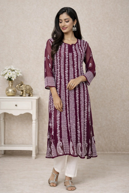Woman wearing a light green embroidered kurta with white pants against a neutral background