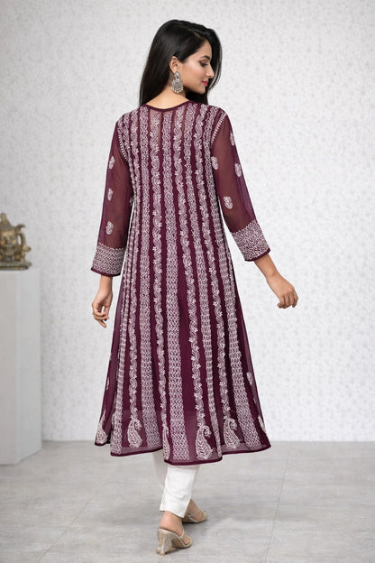 Woman wearing a light green embroidered kurta with white pants against a beige background