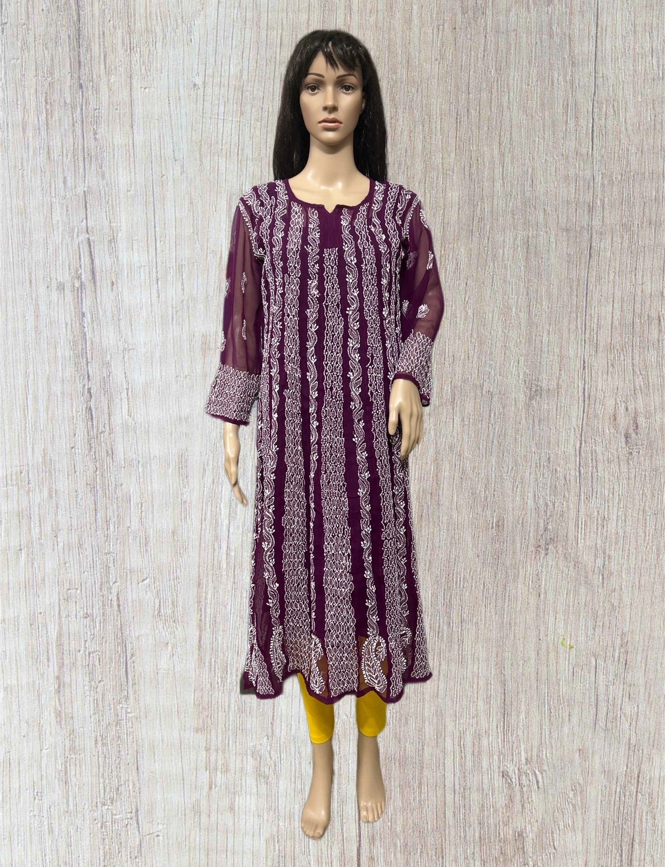 Green embroidered kurta on a mannequin against a gray background