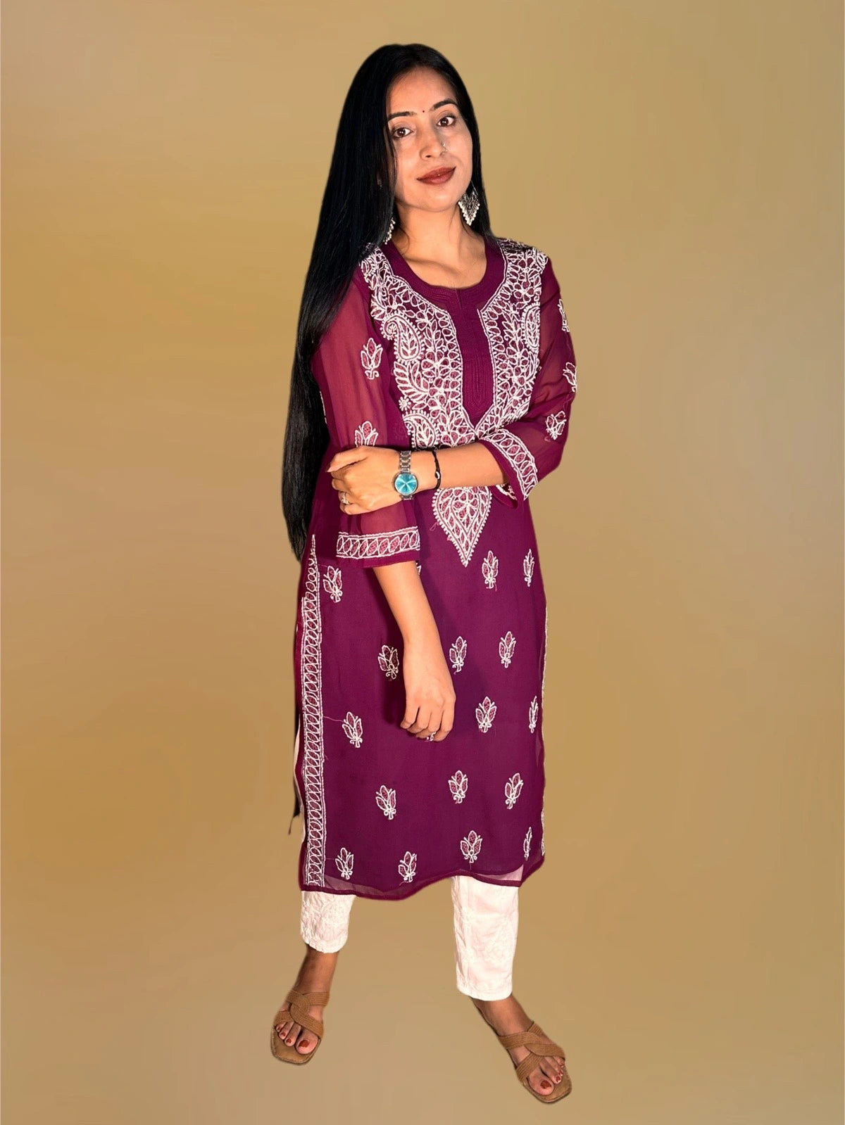 A woman modeling a deep purple kurta with white embroidery and white pants, standing against a solid beige background.