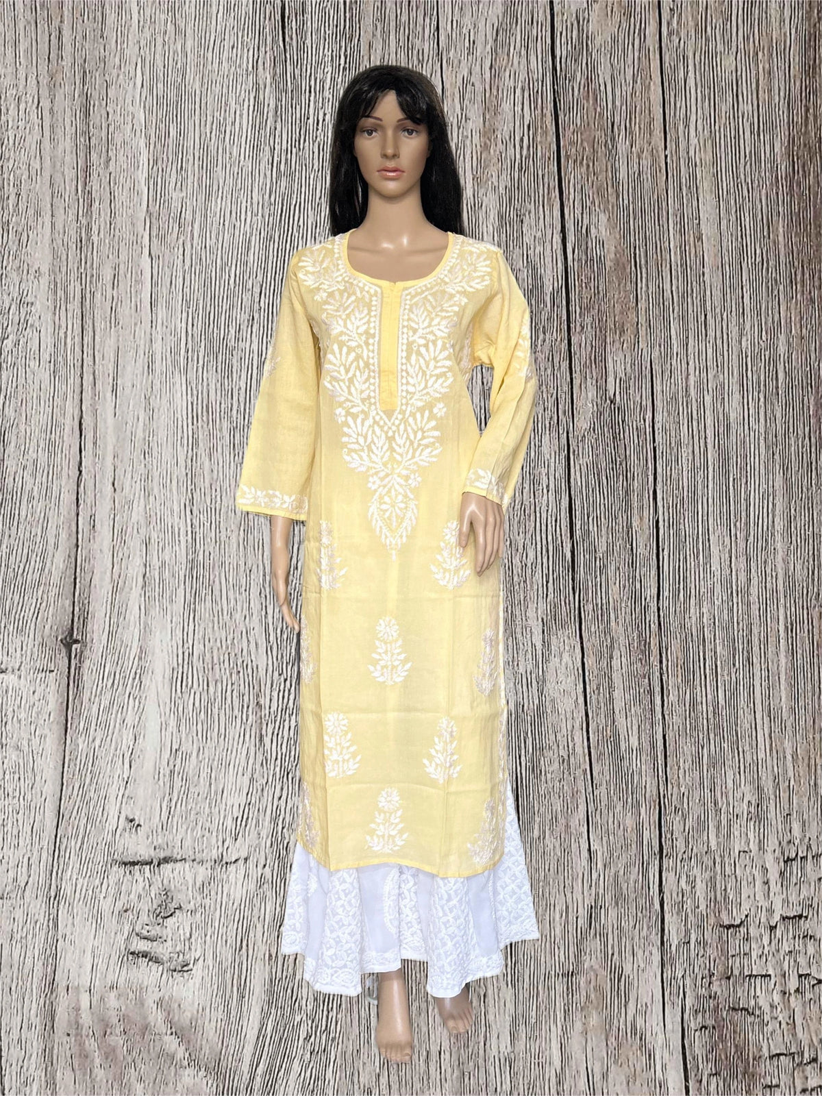A woman modeling a light yellow kurta wooden gray background.