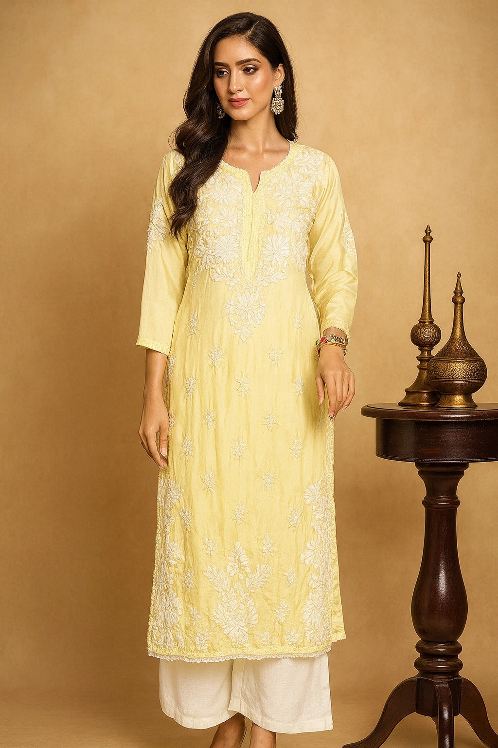 Woman wearing a light yellow kurta with white embroidery against a beige background