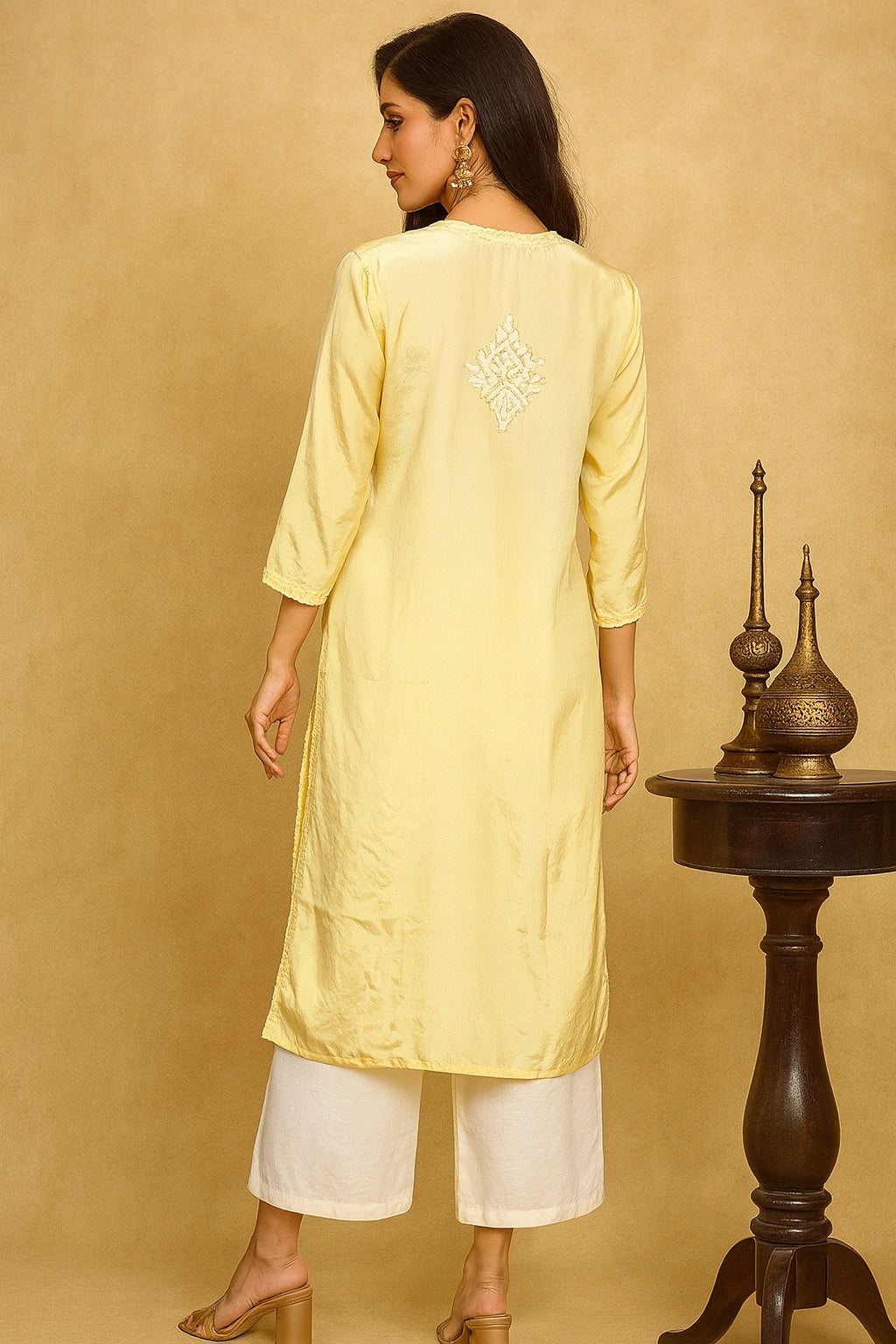 lucknowi chikankari Woman wearing a light yellow kurta with white pants against a beige background