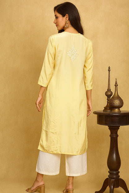 lucknowi chikankari Woman wearing a light yellow kurta with white pants against a beige background