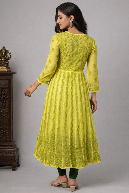 Woman wearing a bright yellow embroidered kurta against a gray background