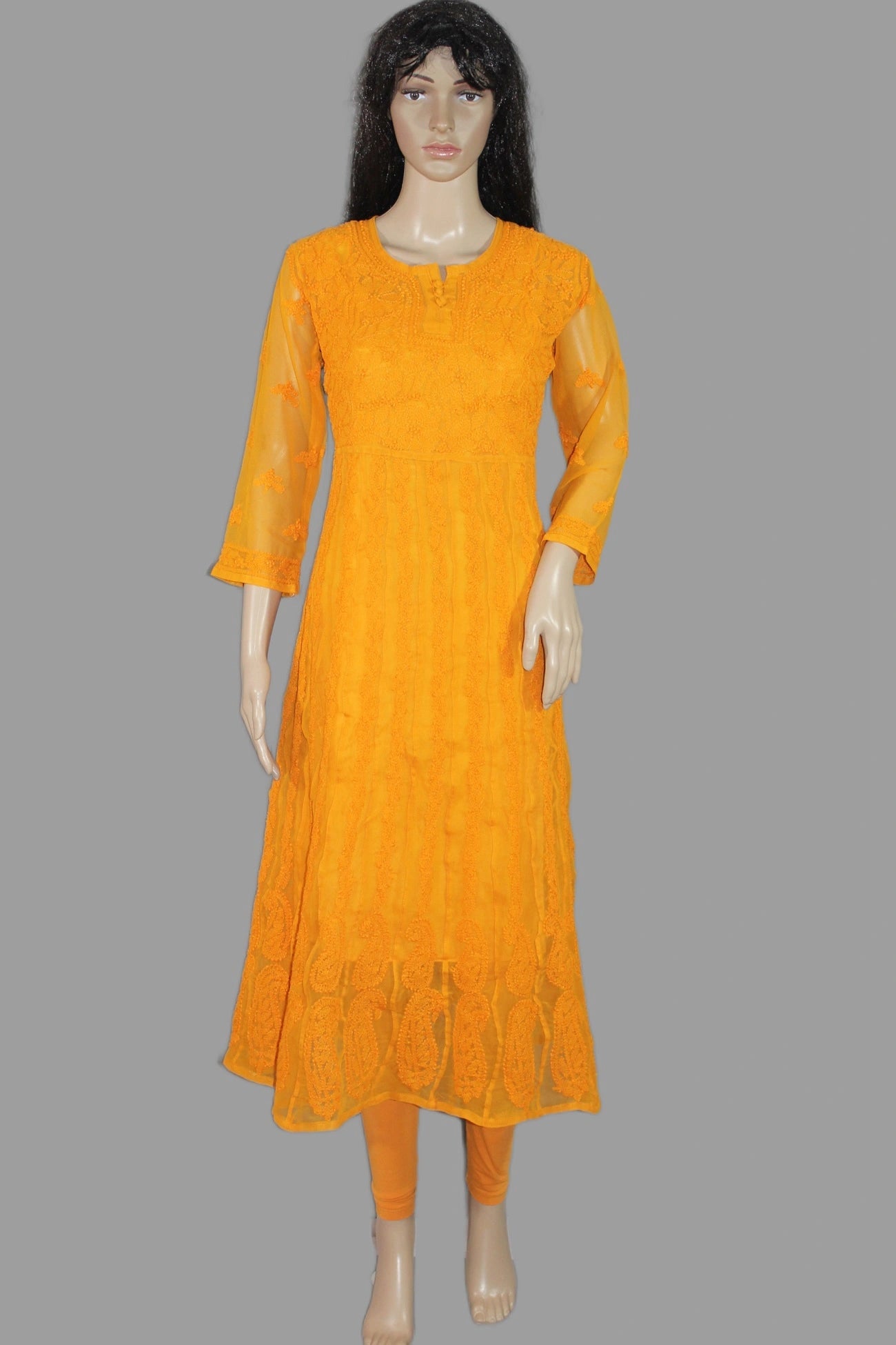 Orange chikan kadhai dress on a mannequin against a gray background