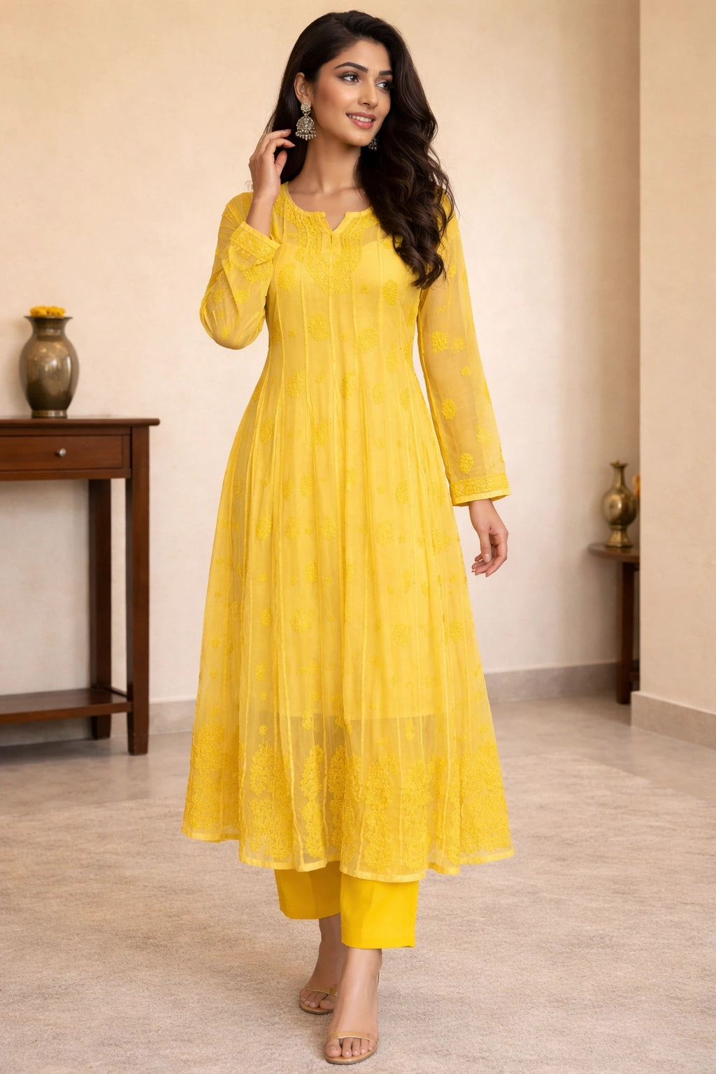 Woman wearing a yellow dress in a room with a wooden table and decorative items.