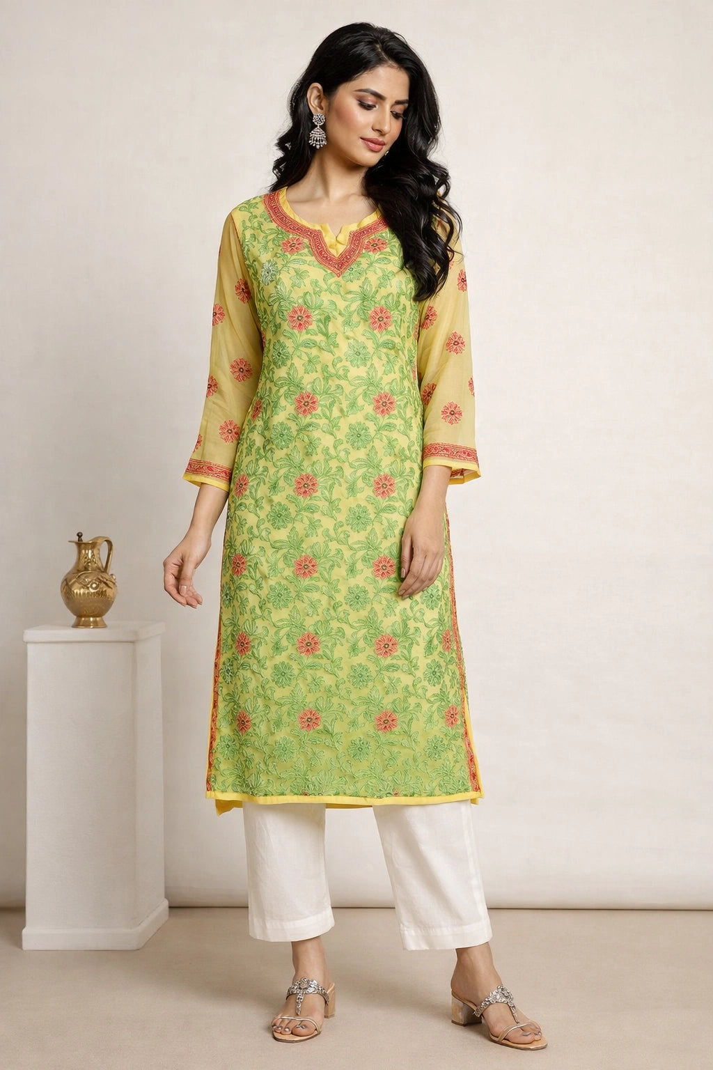 Woman wearing a lucknowi chikan green and yellow traditional outfit with white pants against a plain background