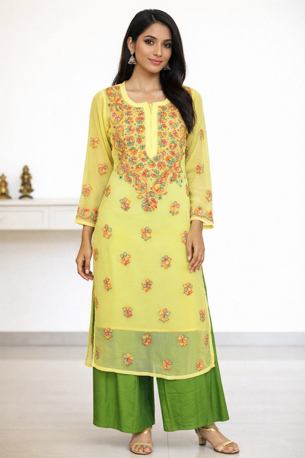 Woman wearing a yellow embroidered kurta with green pants in a minimalistic setting