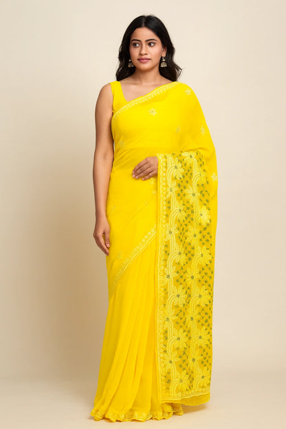 Woman wearing a lucknowi chikankari yellow saree with a floral border on a beige background
