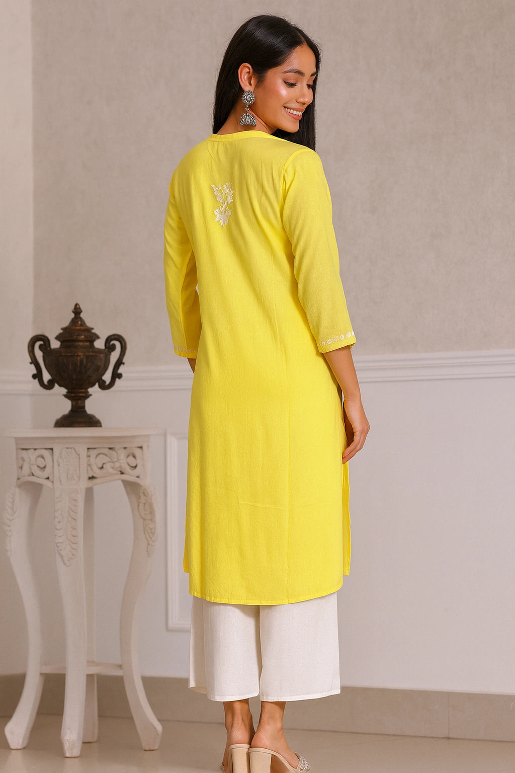 lucknowi chikankari Woman wearing a yellow kurta with white pants in an indoor setting