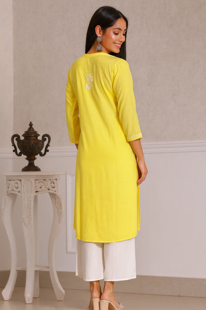 lucknowi chikankari Woman wearing a yellow kurta with white pants in an indoor setting